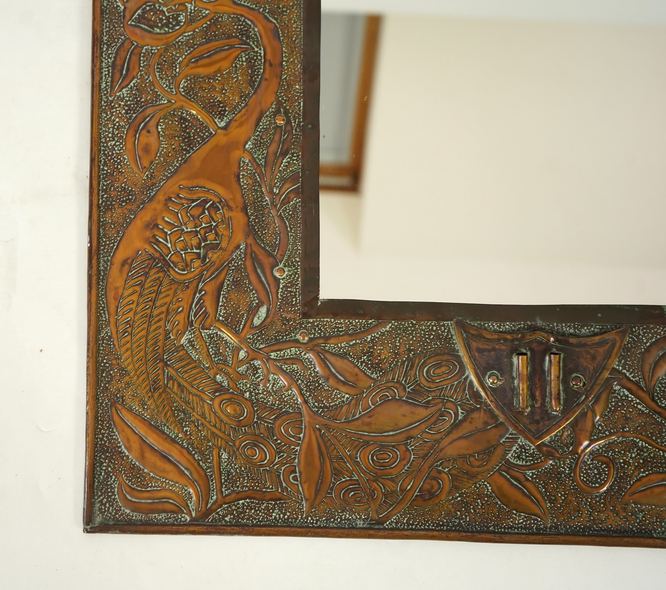 An Arts and Crafts embossed copper mirror, manner of Talwin Morris, Glasgow School